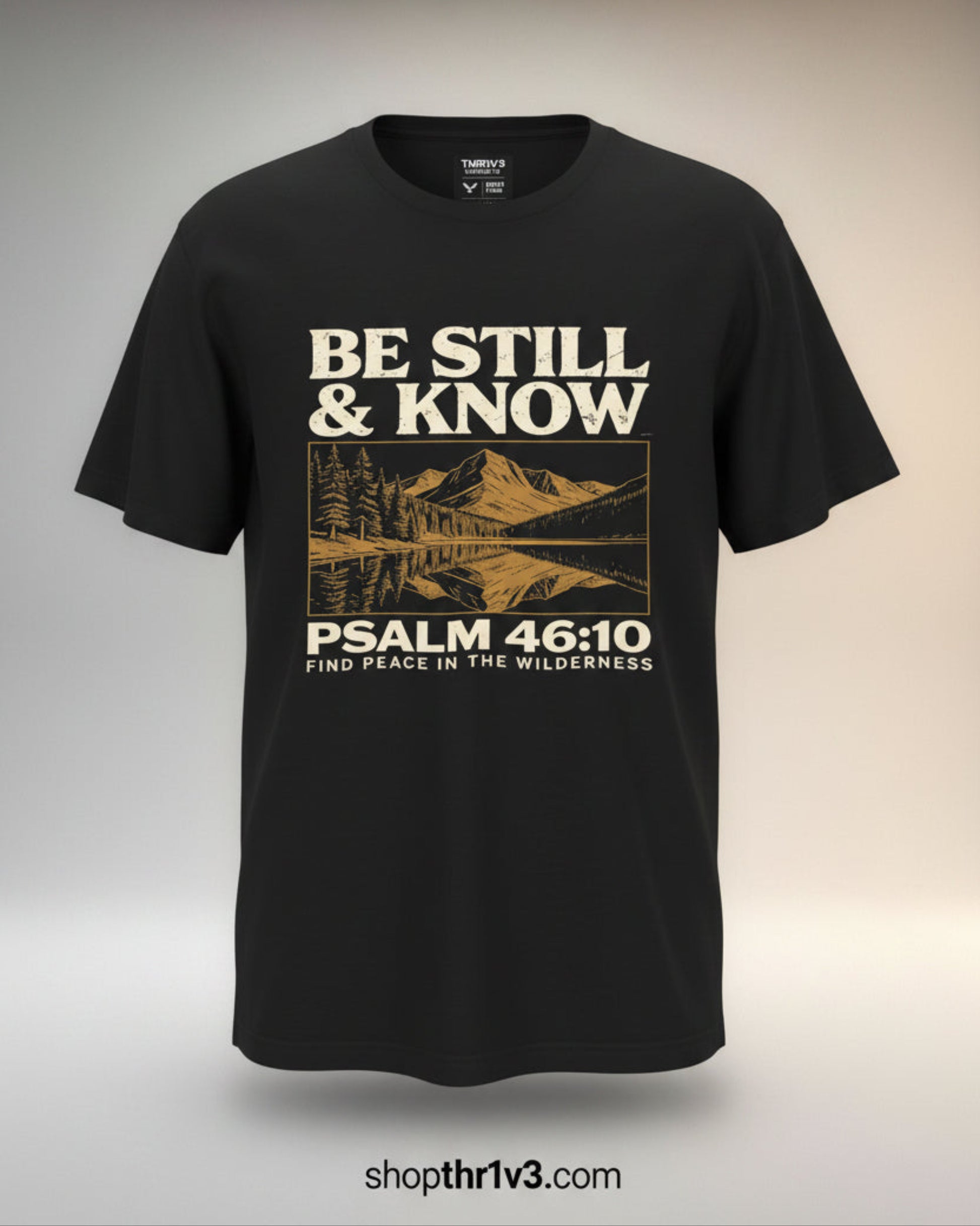 Black t-shirt with 'Be Still & Know' design and mountain graphic on a gray background
